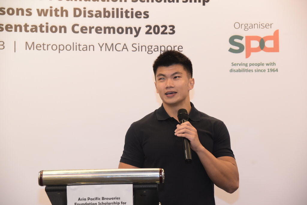 Marcus holding a mic and sharing a presentation at the awards ceremony