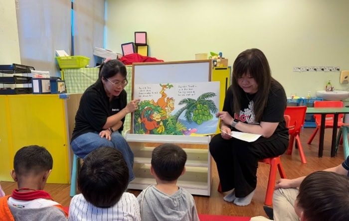 Deloitte staff in a storytelling session with children.