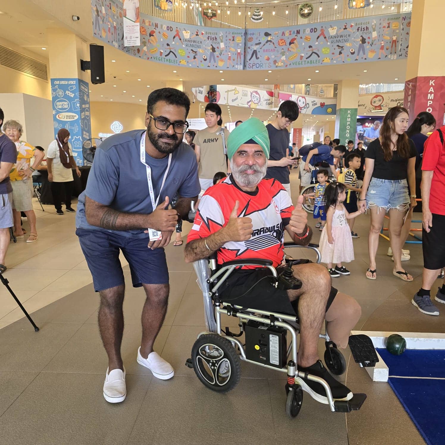 Vinid with a wheelchair user at the E S H Tampines Eat Play Live community event.