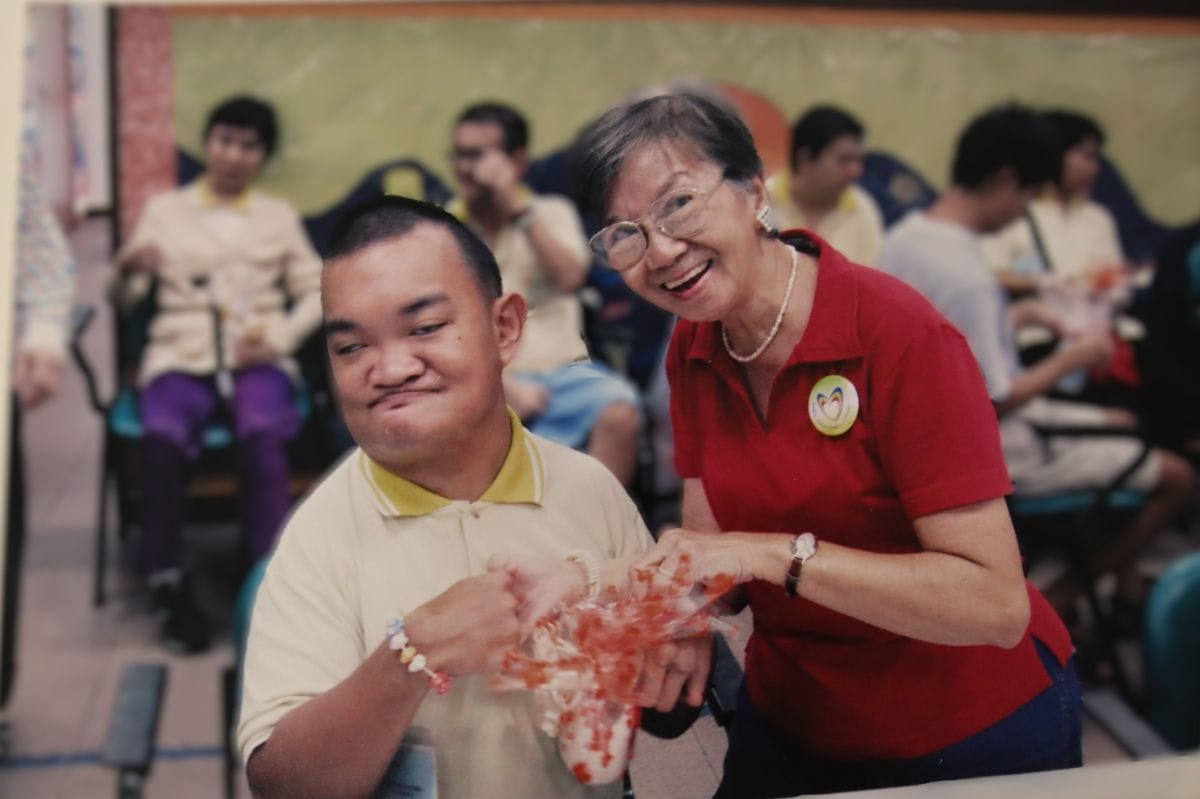 An old photo of Auntie Molly gifting a D A C client a present.