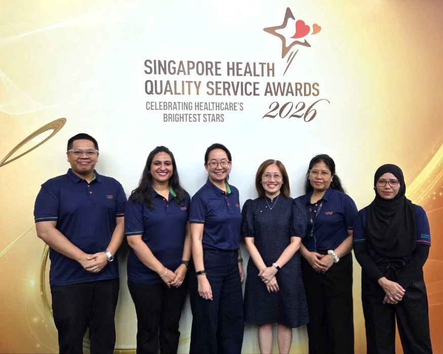 Winners and S P D assistant C E O Ms Tay Soong Kiang against the S H Q S A backdrop