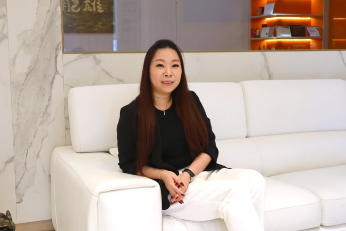 Ms Samantha Lin seated, with the Fei Siong logo in the background