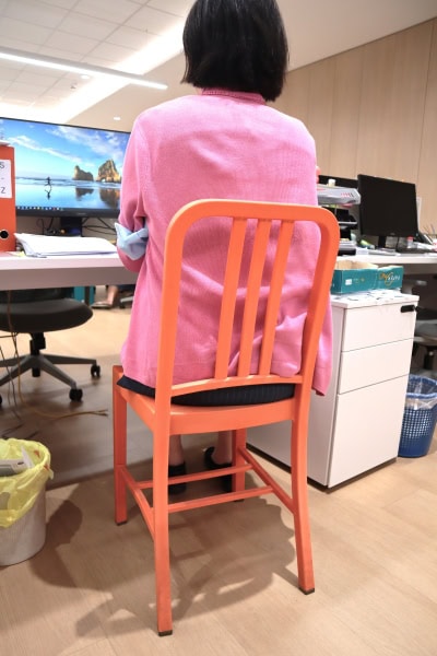 Back view of a person seated on a sturdy chair