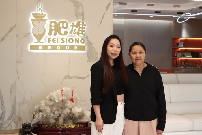 Ms Samantha Lin with Ms Julia Poh at beside the Fei Siong logo