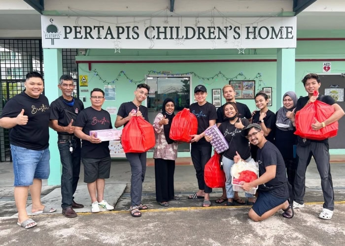 Fei Siong Group staff with care packs in front of Pertapis Children's Home