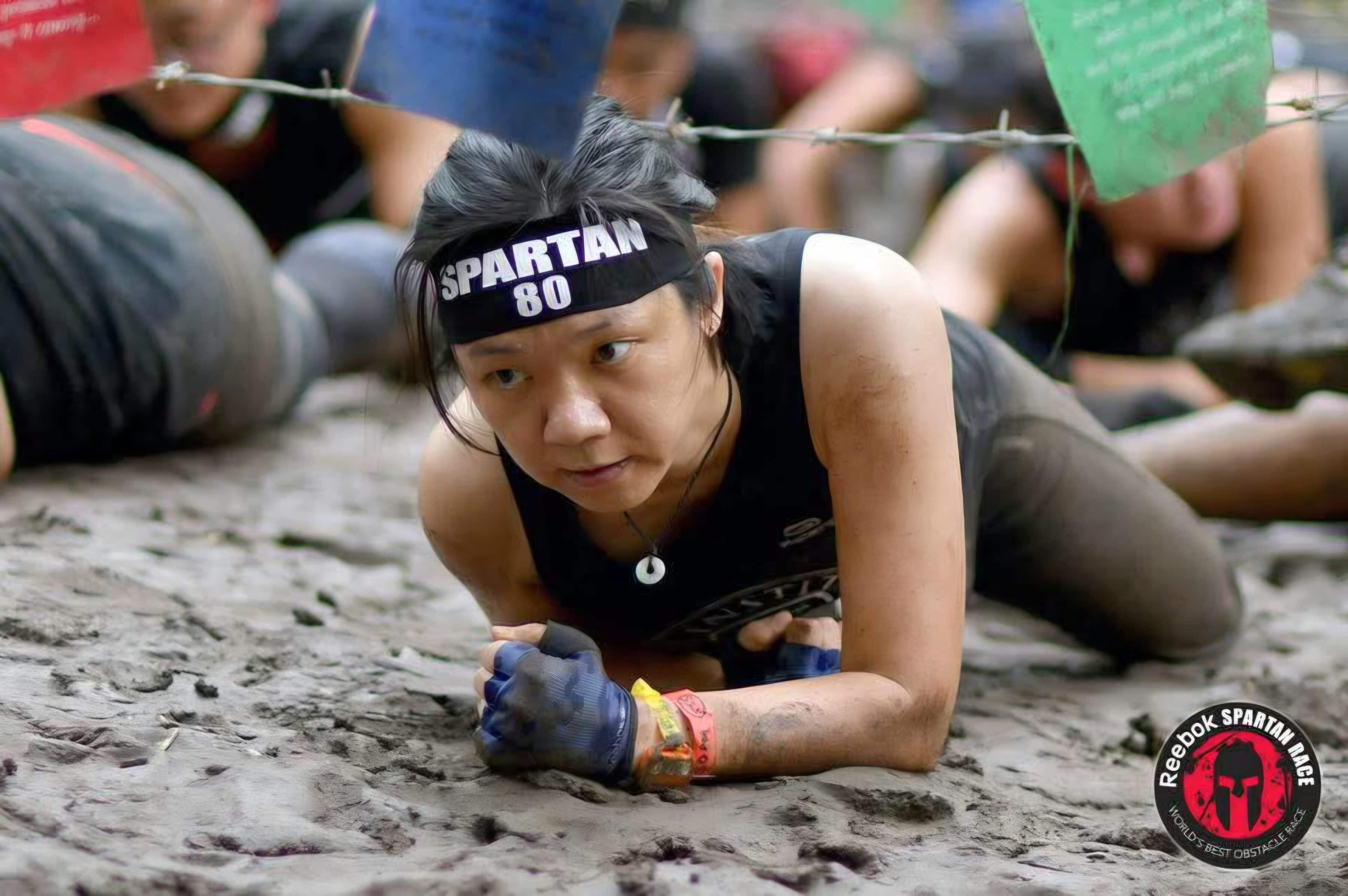 Alexis doing a leopard crawl in the mud at the Spartan Race