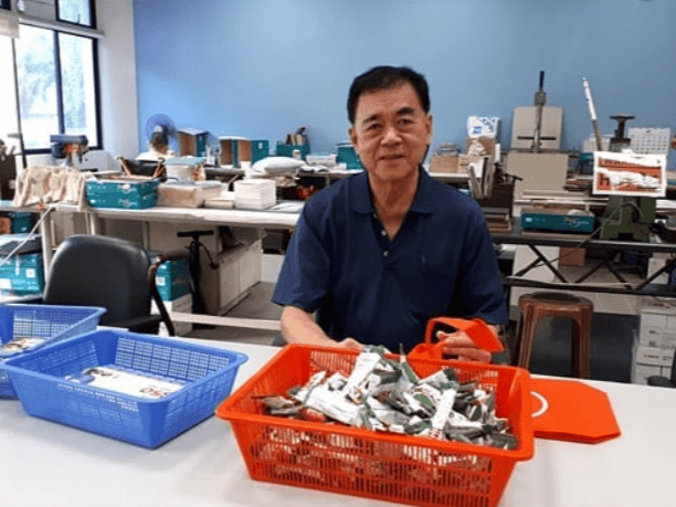 A Familiar Face at the Sheltered Workshop 1 Mr Wang smiling at his work station