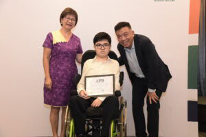 Mrs Sim, Aaron and Mr Sim smiling for a photo