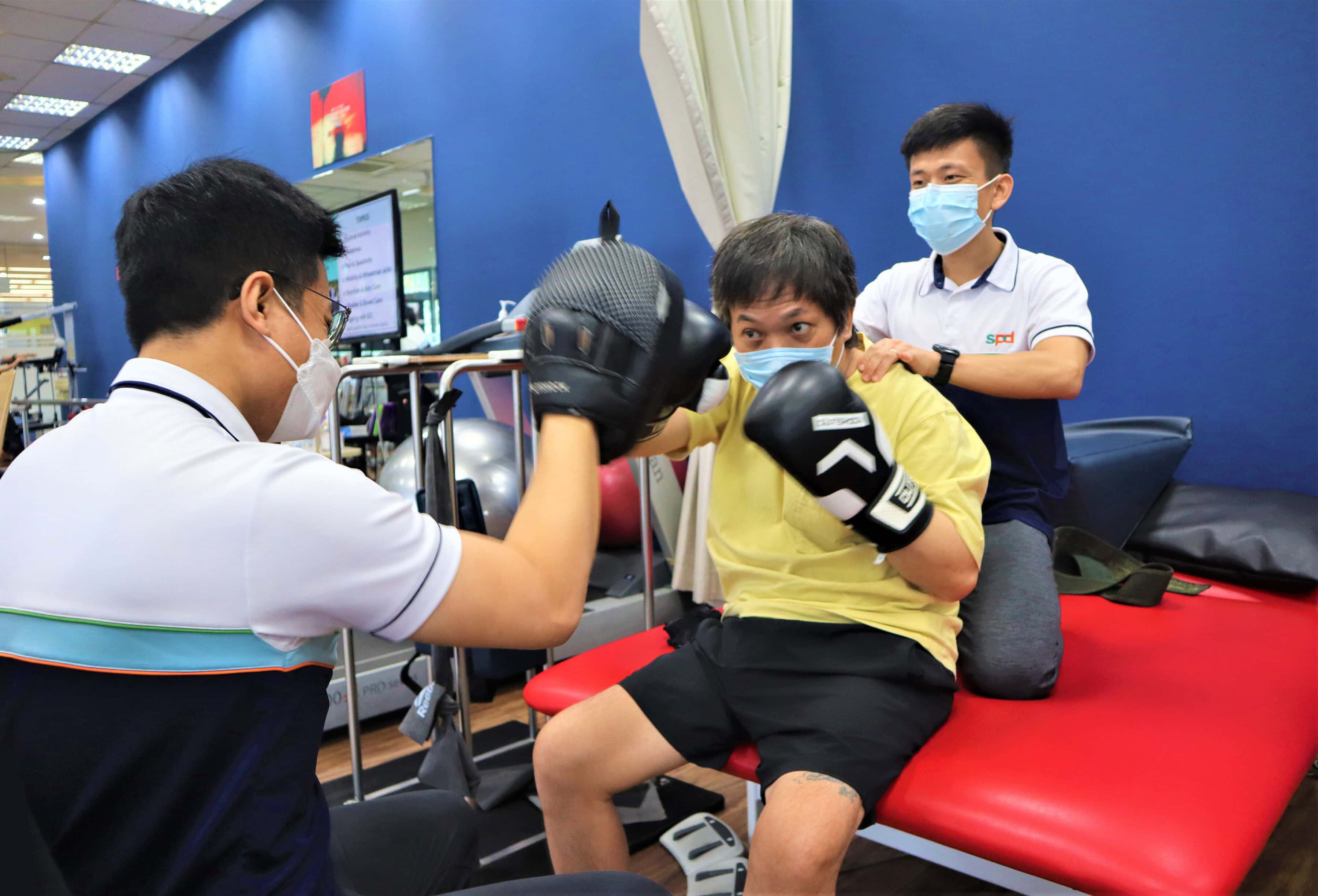 Bradley and a fellow therapist with a client in boxing exercise