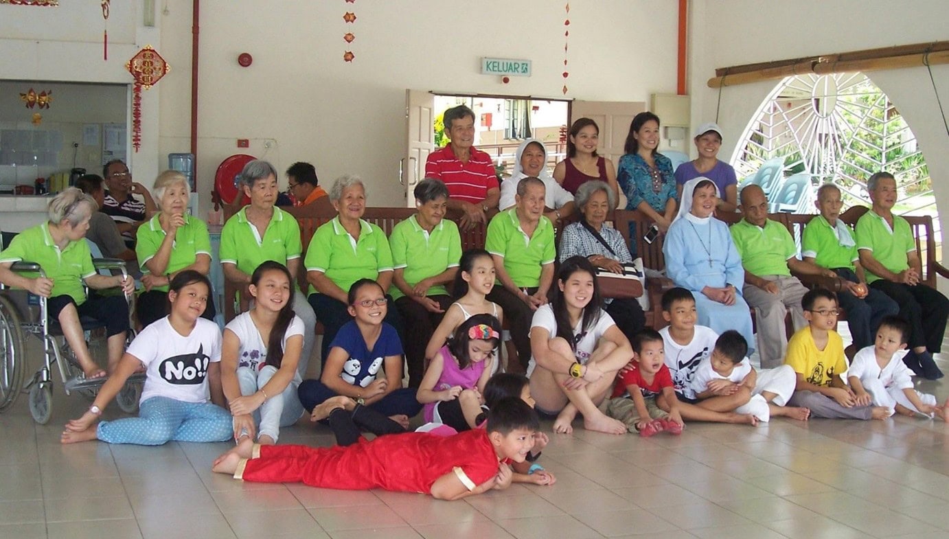 Sharon smiling for a photo with a group of people in Sarawak for a volunteering event.